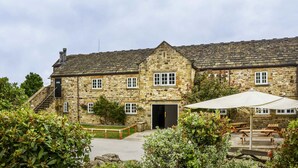 A stone building with a central entrance, windows, and a staircase.