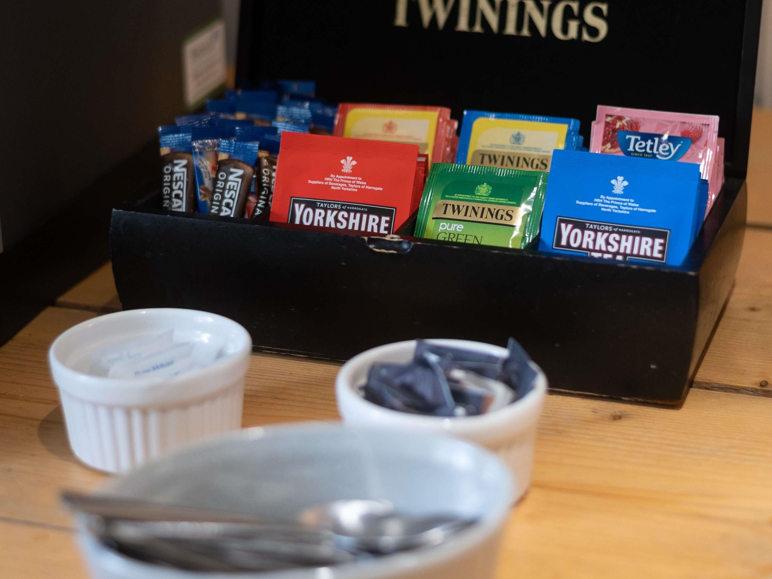 A display of tea bags with brands like Yorkshire, Twinings, and Tetley.