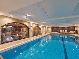 Una piscina cubierta, tumbonas