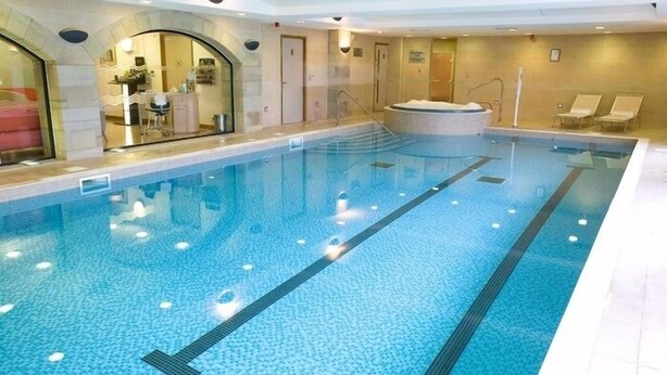 An indoor swimming pool with clear lanes, a hot tub, and lounge chairs. - Mercure Barnsley Tankersley (Barnsley)