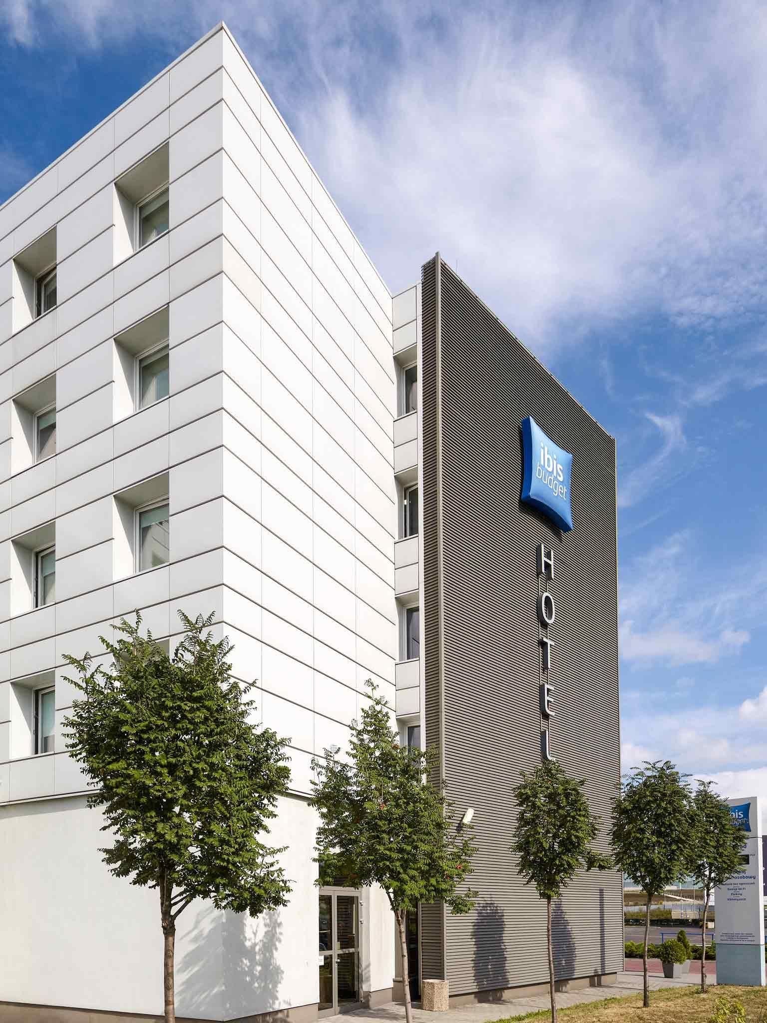 Un hotel moderno con fachada blanca y una sección texturizada distintiva a la derecha.