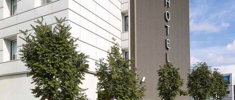 Un hotel moderno con fachada blanca y una sección texturizada distintiva a la derecha.