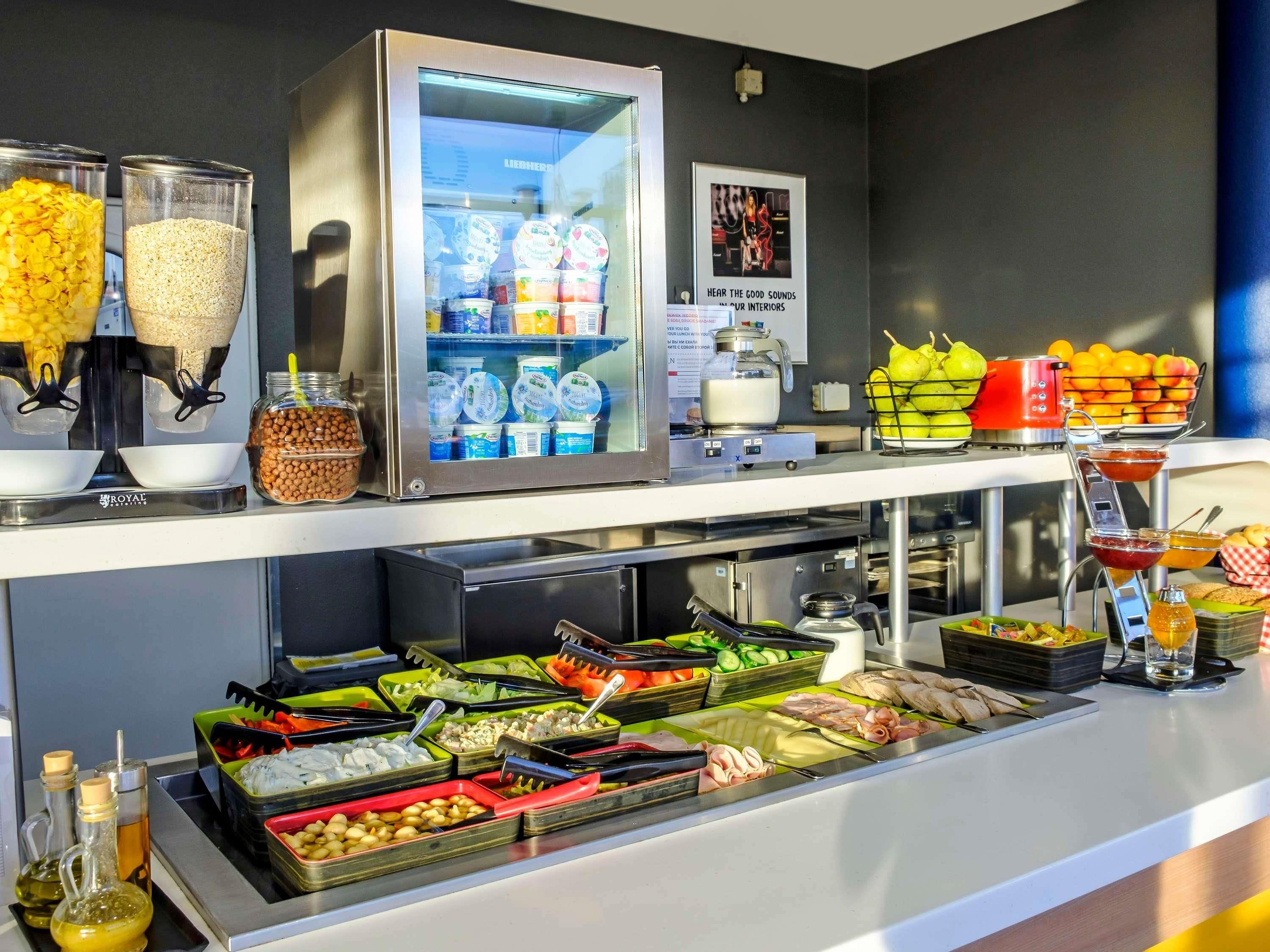 A buffet with various food items, a refrigerator with dairy products, and a fruit basket.
