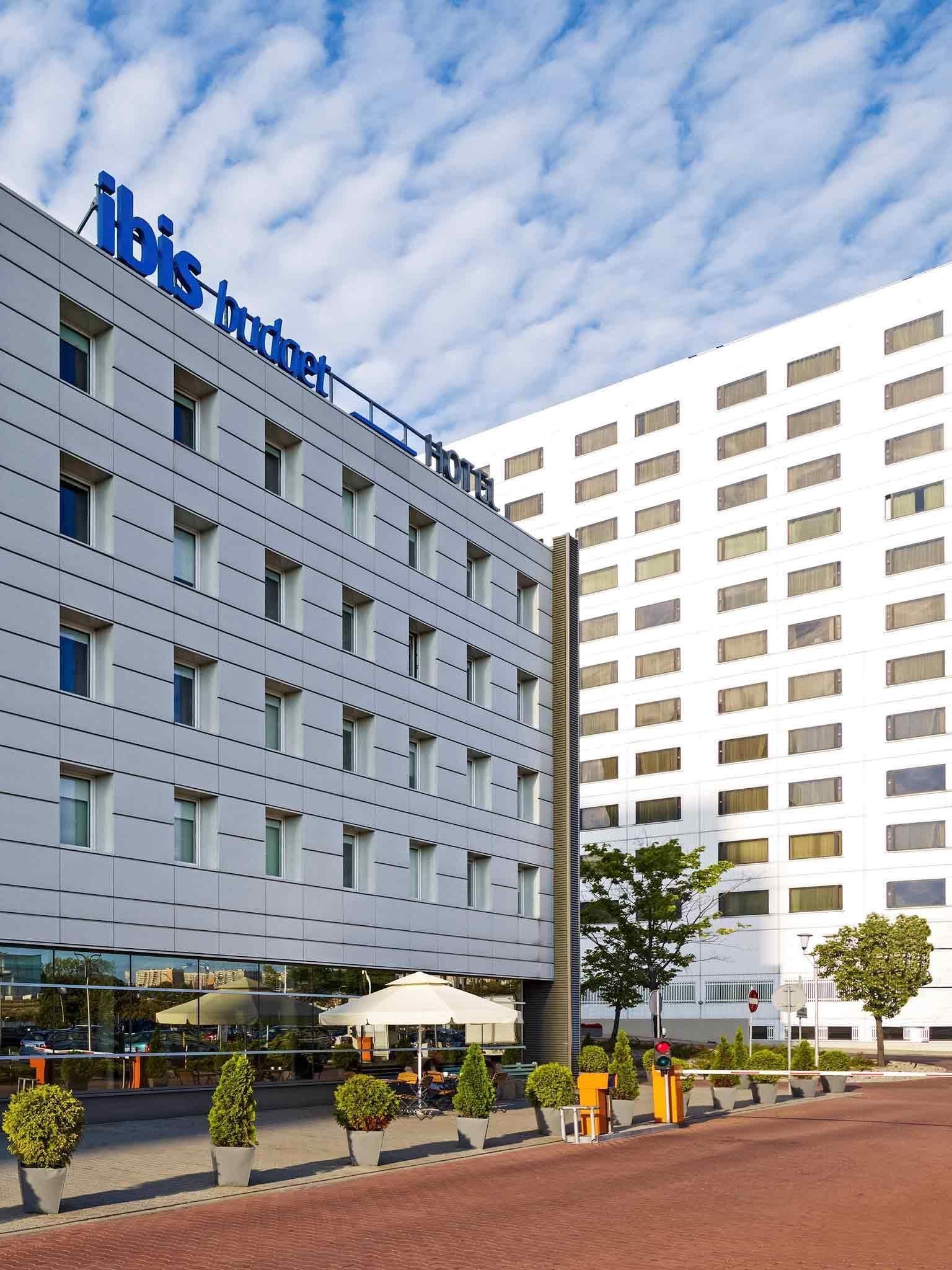 Un edificio moderno de hotel con fachada plana, numerosas ventanas y un llamativo letrero que dice "ibis Budget Hotel".