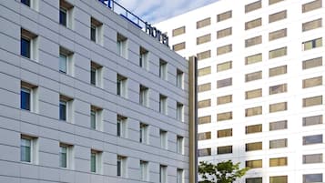 Un edificio moderno de hotel con fachada plana, numerosas ventanas y un llamativo letrero que dice "ibis Budget Hotel".