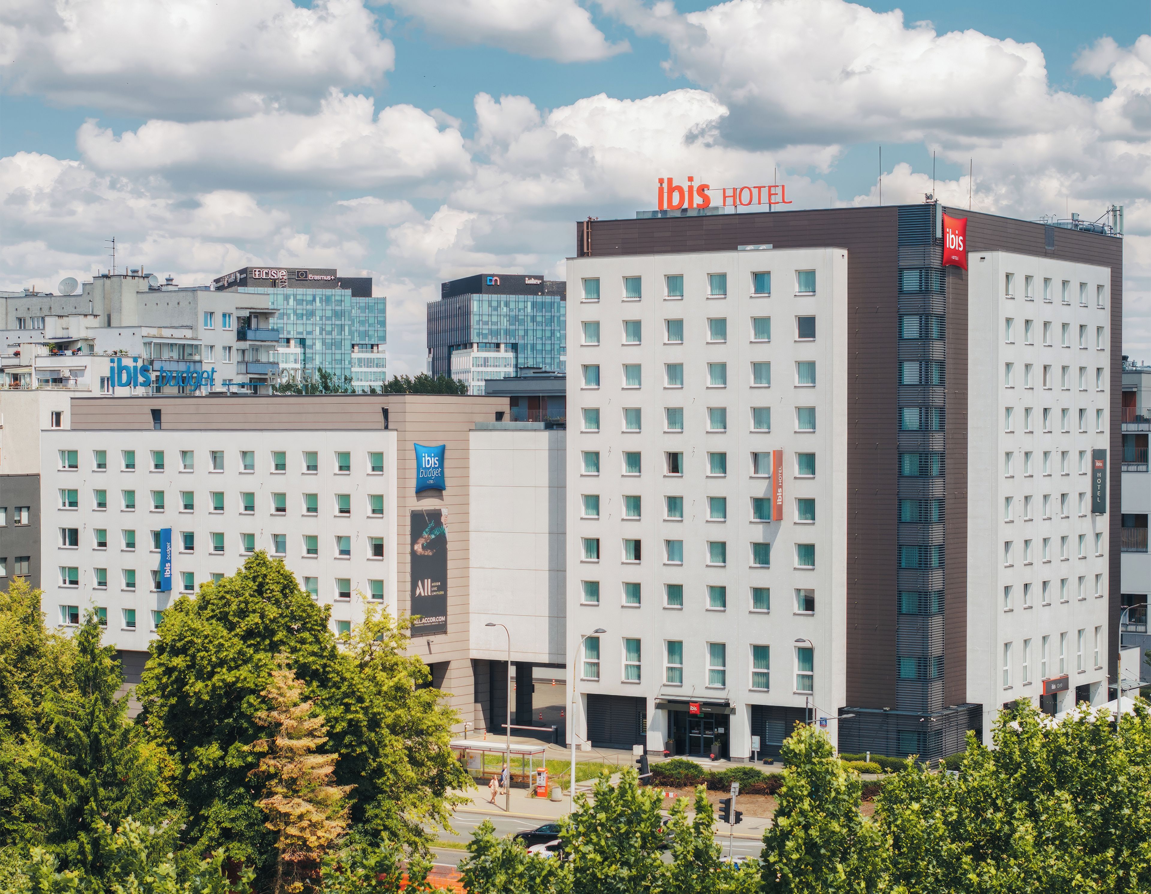 A hotel with a modern design, multiple floors, and a prominent 'ibis HOTEL' sign.