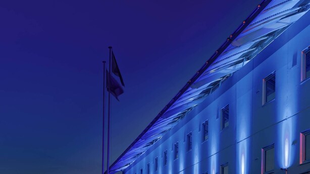 Un edificio con asta de bandera y varias ventanas.