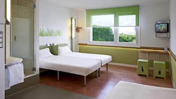 Quarto de hotel com cama, janela com vista, espelho e televisão.