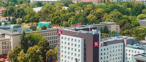 Et højt hotel med flere etager, et markant rødt flag i hjørnet og udsigt over byens skyline.