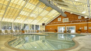 An indoor swimming pool with a glass ceiling, a no-diving sign, and a 3ft depth marker.