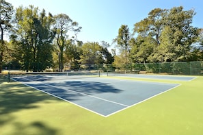 A tennis court with a net, surrounded by trees. - AMAZING HOME in Four Seasons in Duck! Private Pool! 10% OFF available summer weeks! (Duck)