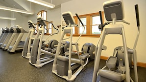 A row of treadmills in a gym with a window and a ceiling light fixture. - AMAZING HOME in Four Seasons in Duck! Private Pool! 10% OFF available summer weeks! (Duck)