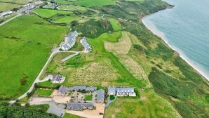 An aerial view of a coastal property with multiple buildings, green fields, and a beach. - Stables 3 -  a llyn peninsula that sleeps 2 guests  in 1 bedroom (Pwllheli)