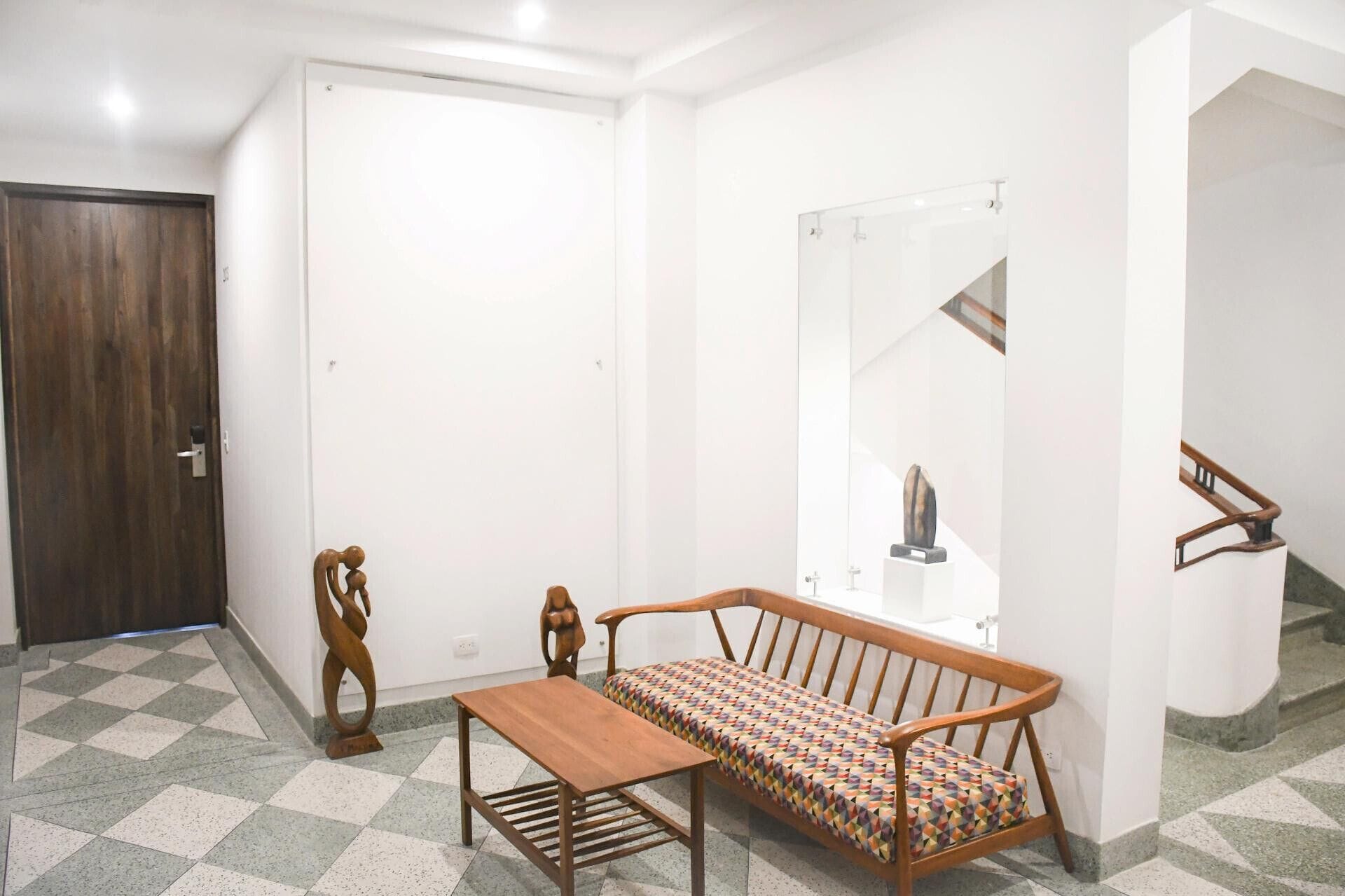 A room with a wooden bench, a door, and a mirror.