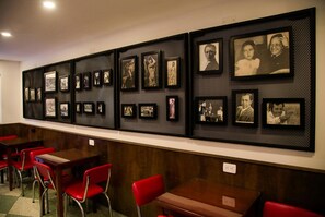 A wall with multiple framed photographs arranged in a grid pattern. - Hotel Museo San Moritz (Bogotá)