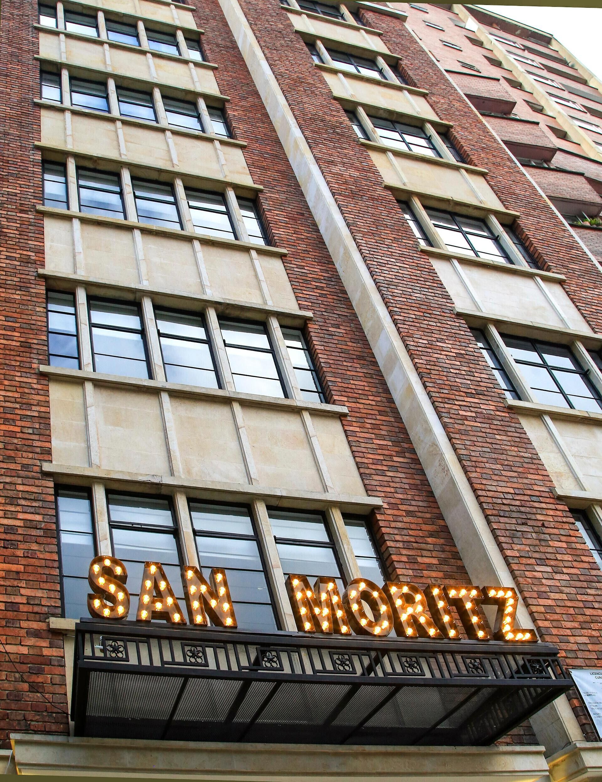 Fachada de edificio con un cartel de espectáculos que dice 'SAN MORITZ'.
