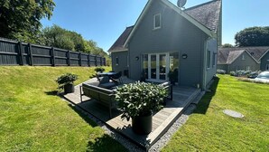 Una casa con patio, mobiliario exterior y una antena parabólica.