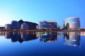 A modern cityscape with a calm lake reflecting buildings. - Stylish Desert Oasis in Tempe (Tempe)