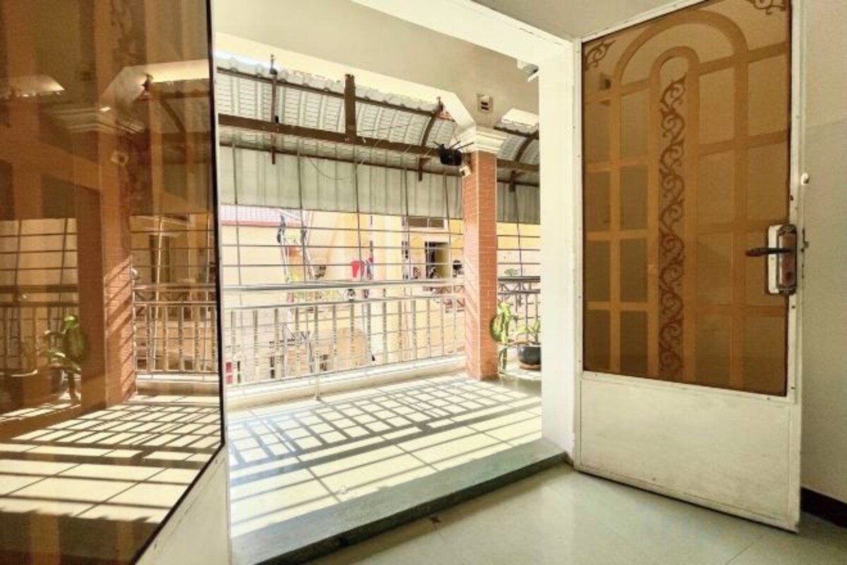 A traditional Japanese-style entrance with a sliding door, a tiled floor, and a view of the outside balcony.