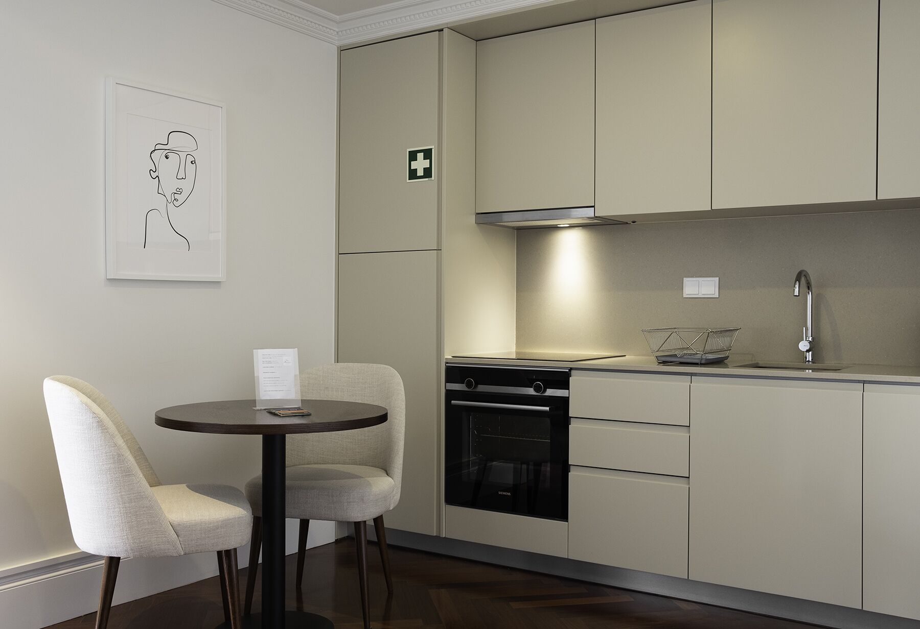 Eine moderne Küche mit Essbereich, ausgestattet mit einem Siemens-Ofen, einer Edelstahl-Dunstabzugshaube und einem minimalistischen Design.