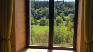 Una habitación con un amplio ventanal que da a un paisaje boscoso.