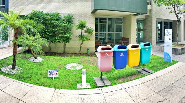 Entrada de un edificio con un cartel que indica zona de reciclaje.