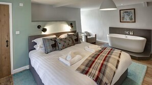 A modern bedroom with a large bed, a built-in bathtub, and a cozy atmosphere.