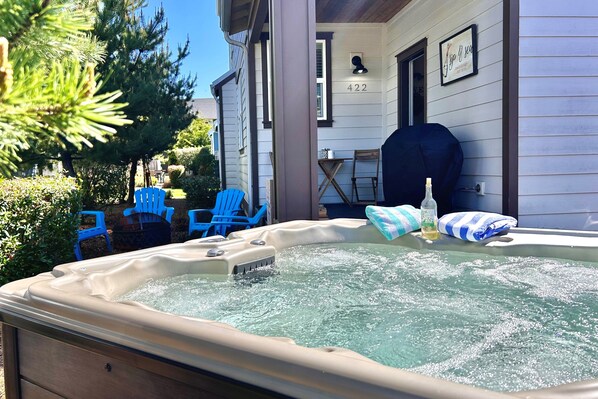 A hot tub with a wooden deck, blue chairs, and a house number 422.