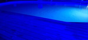 Una piscina al aire libre de temporada, sombrillas