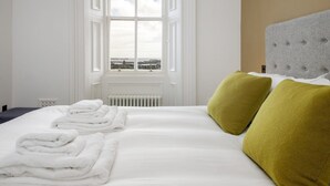 Habitación de hotel con una cama grande, dos almohadas, un radiador y una ventana con vistas.