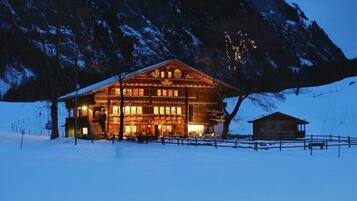 Vista frontal de la propiedad por la tarde o noche