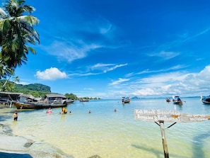 A beach with clear water, boats, and a sign for Koh Moo Khe Beach Resort. - Kohmook Seaview Bungalow (Ko Mook)
