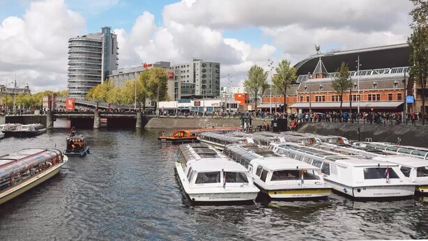 A marina with several boats docked, a bridge, and buildings in the background. - Dase Bed & Breakfast (Amsterdam)