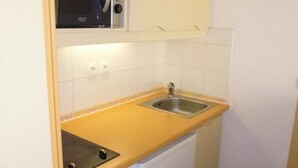 A compact kitchen with a microwave, sink, and dishwasher. - South-Facing Studio for 4 with Balcony, Ski-In/Ski-Out Access (La Mongie)