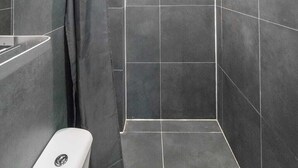 A modern bathroom with a shower, a toilet, and a mirror. - Amazing B&B (Amsterdam)