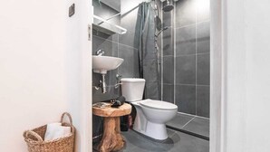 A modern bathroom with a toilet, sink, and shower. - Amazing B&B (Amsterdam)