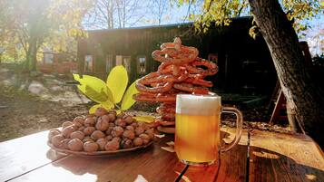 A wooden table with a plate of walnuts, a stack of pretzels, and a mug of beer.