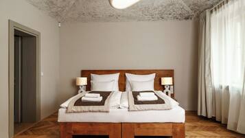 A double bed with a wooden frame, two bedside tables with lamps, and a ceiling light fixture.