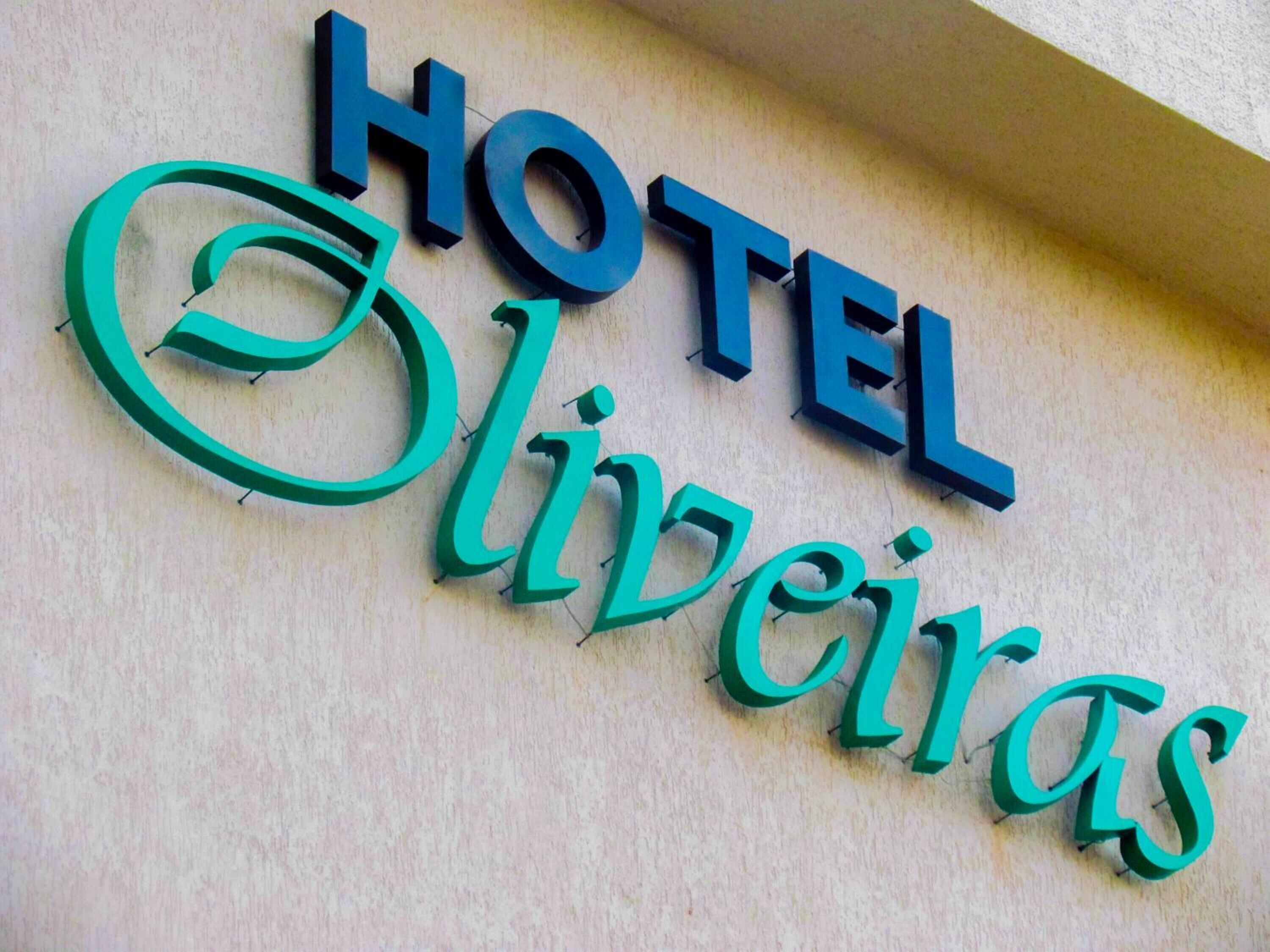 Un letrero de hotel con el nombre 'HOTEL Oliveiras' en letras grandes y negritas.
