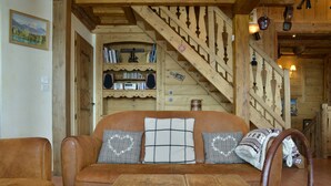 Un intérieur en bois avec un canapé, une table en bois et un escalier.