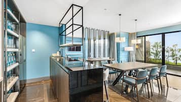 A modern kitchen with a marble countertop, a built-in wine rack, and a dining area with a large table and chairs.