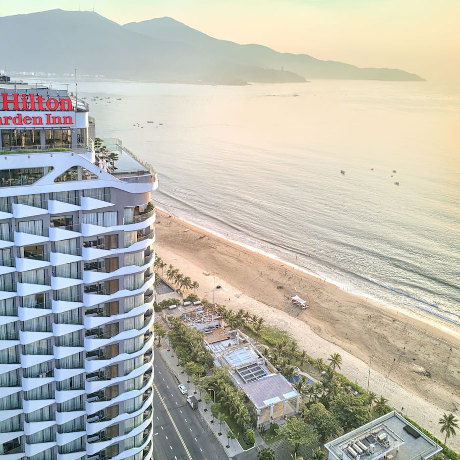 A high-rise hotel with a view of the beach and ocean.