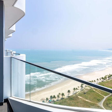 A balcony with a view of a beach and ocean.