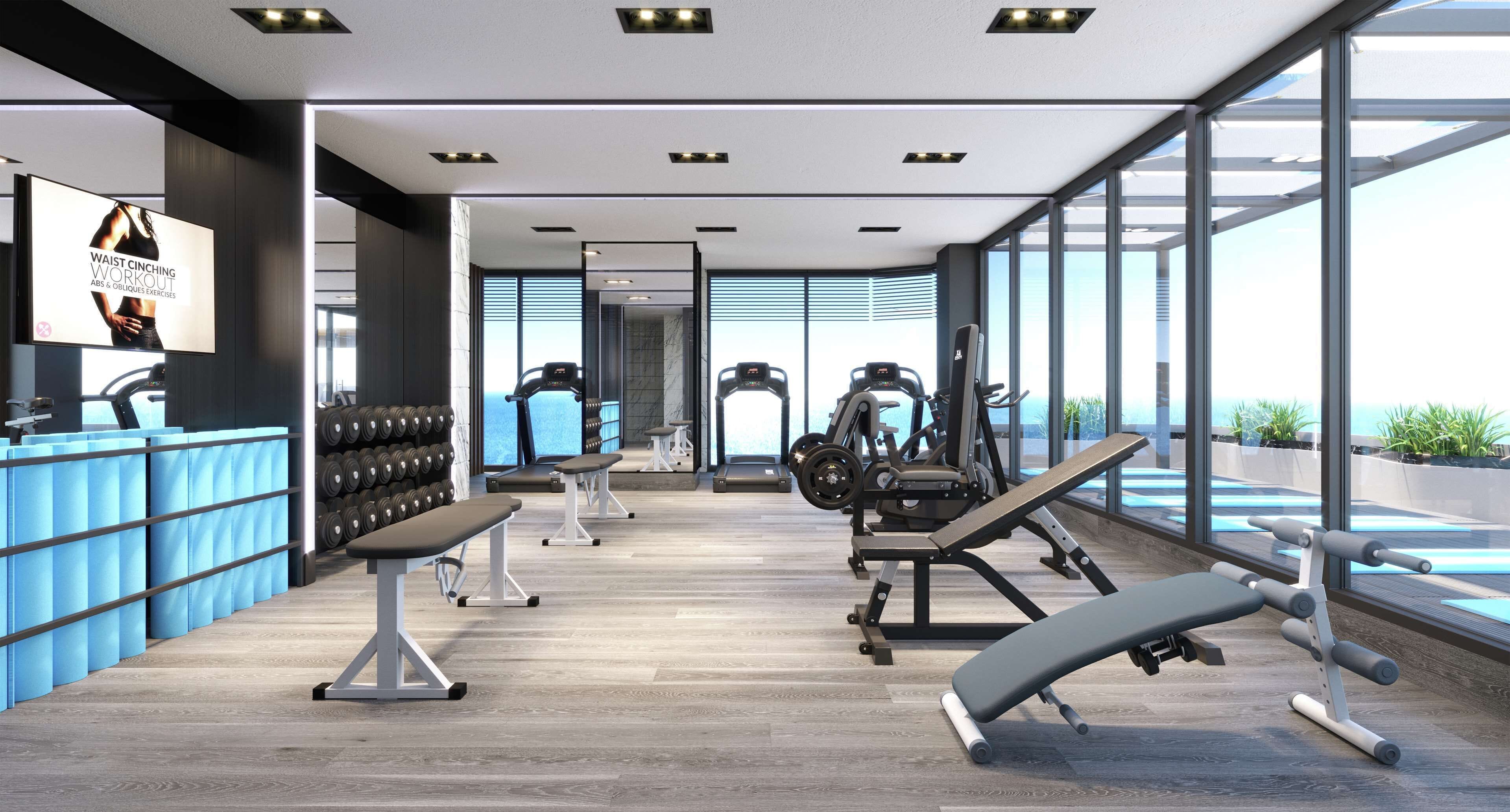 A modern gym with exercise equipment, a large mirror, and a view of the outdoors.