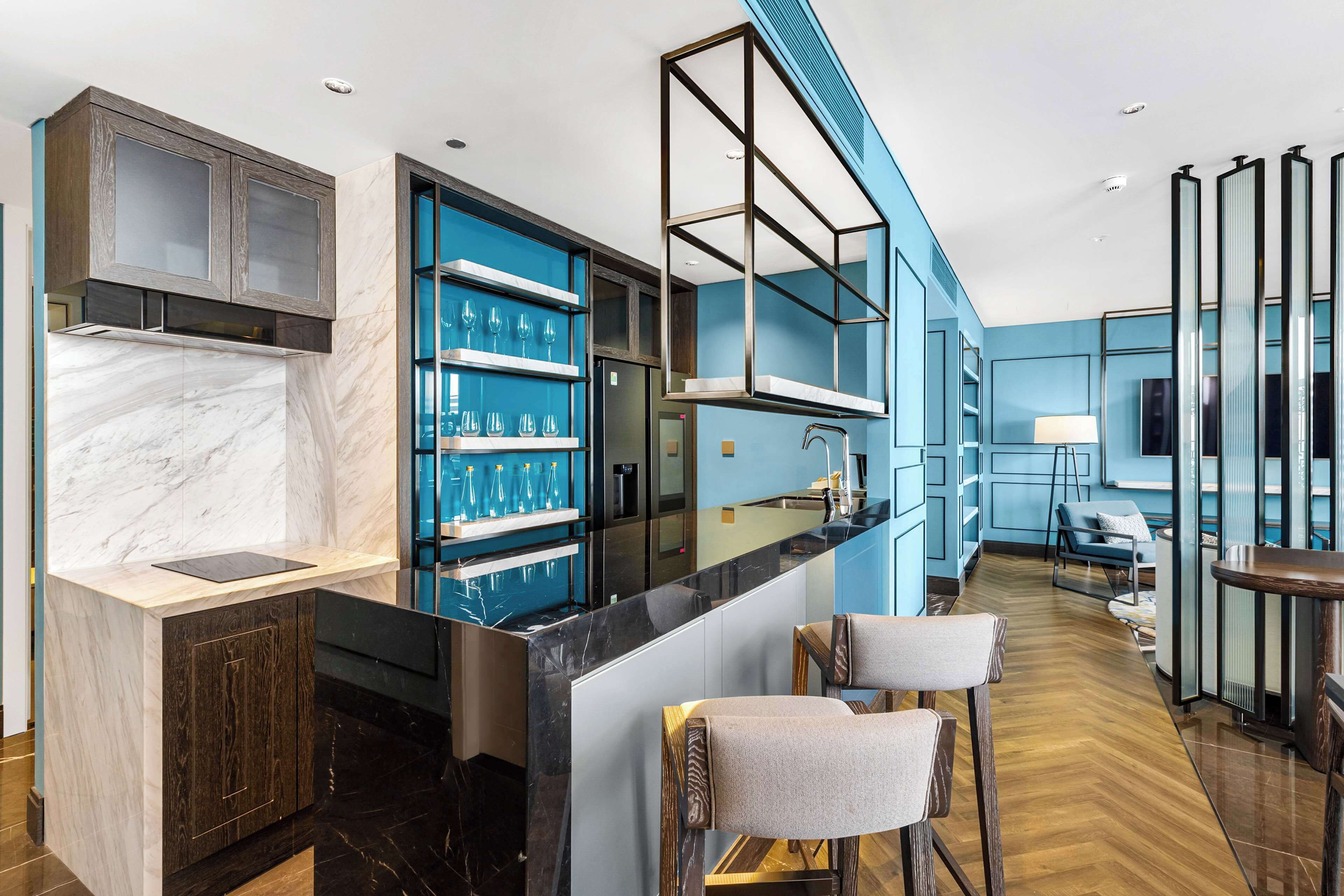 A modern kitchen with marble countertops, a built-in wine rack, and a bar area with stools.