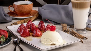 A dessert plate with strawberries, a scoop of ice cream, and a cherry on top.