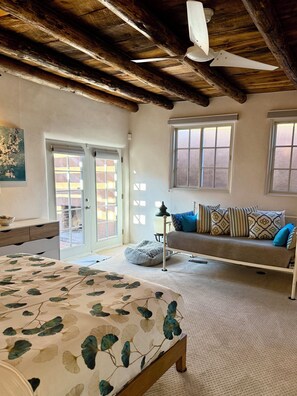 Ett sovrum med en säng, en bänk och ett fönster.