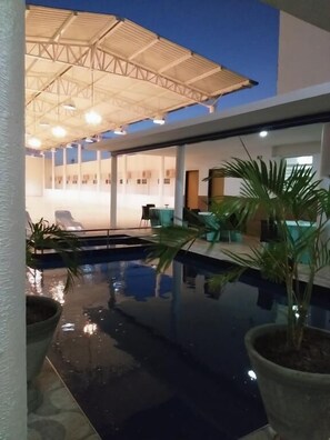 An indoor swimming pool with a covered area, seating, and potted plants. - Hotel Cajuina Beach (Parnaíba)