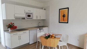 Cafetera o tetera, frigorífico, microondas y placa de cocina