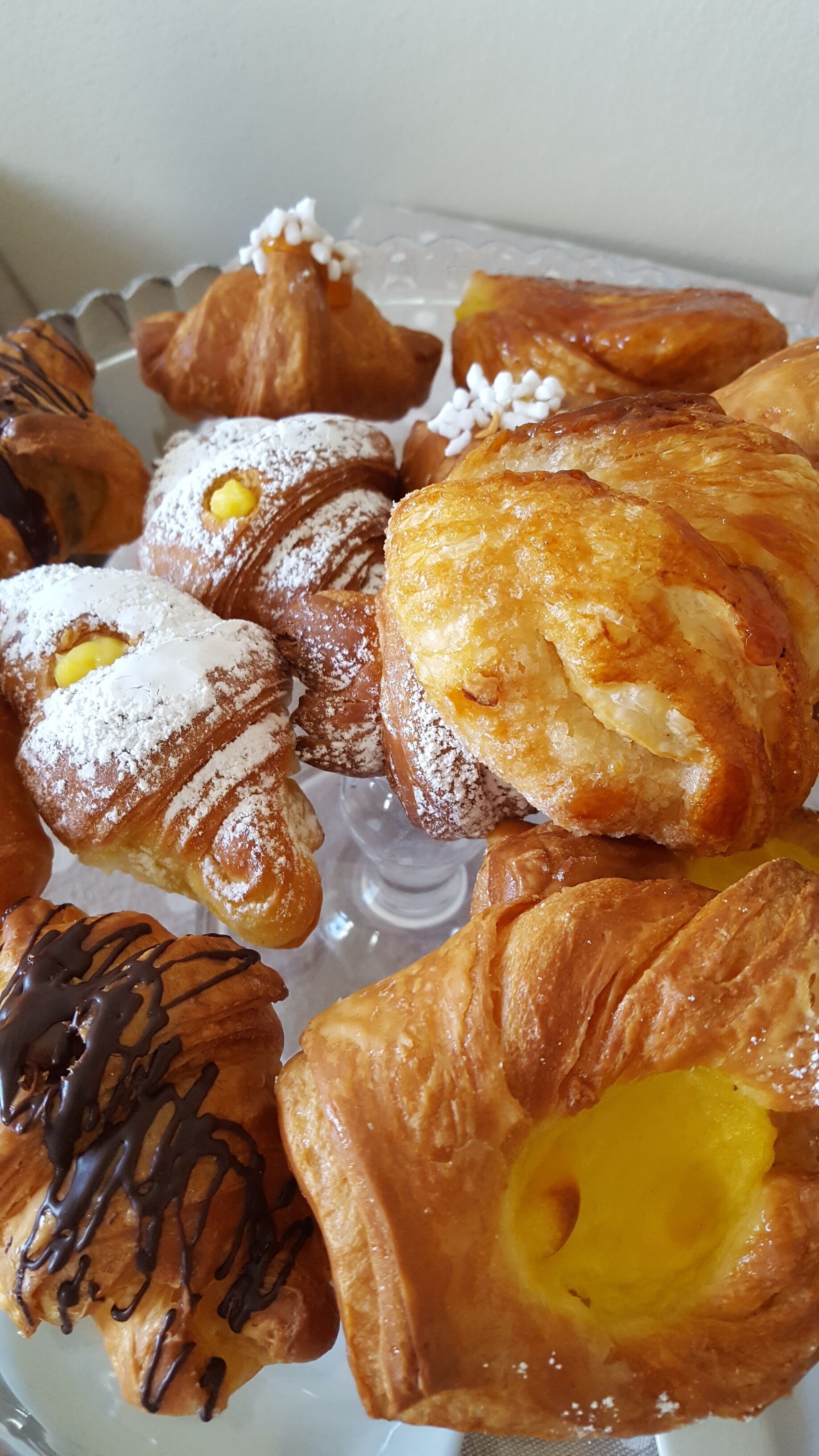Une variété de pâtisseries présentées sur un plateau en verre.